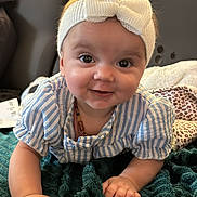 Mencïa participe au concours pour gagner de l'argent avec cette photo : baby, infant, headband, bow, smile, blanket, teal_blanket, striped_shirt, crawling, chubby_cheeks, big_eyes, necklace, couch, cozy, portrait, closeup, hand, living_room, plush, rolled_blanket