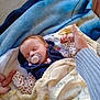 Evelynn is registered to the contest to win money with this photo: baby, sleeping, blanket, pacifier, hand, adult_hand, cozy, indoor, child, comfort, soft, warm, clothing, person, toddler, cute, peaceful, rest, sleep, infant