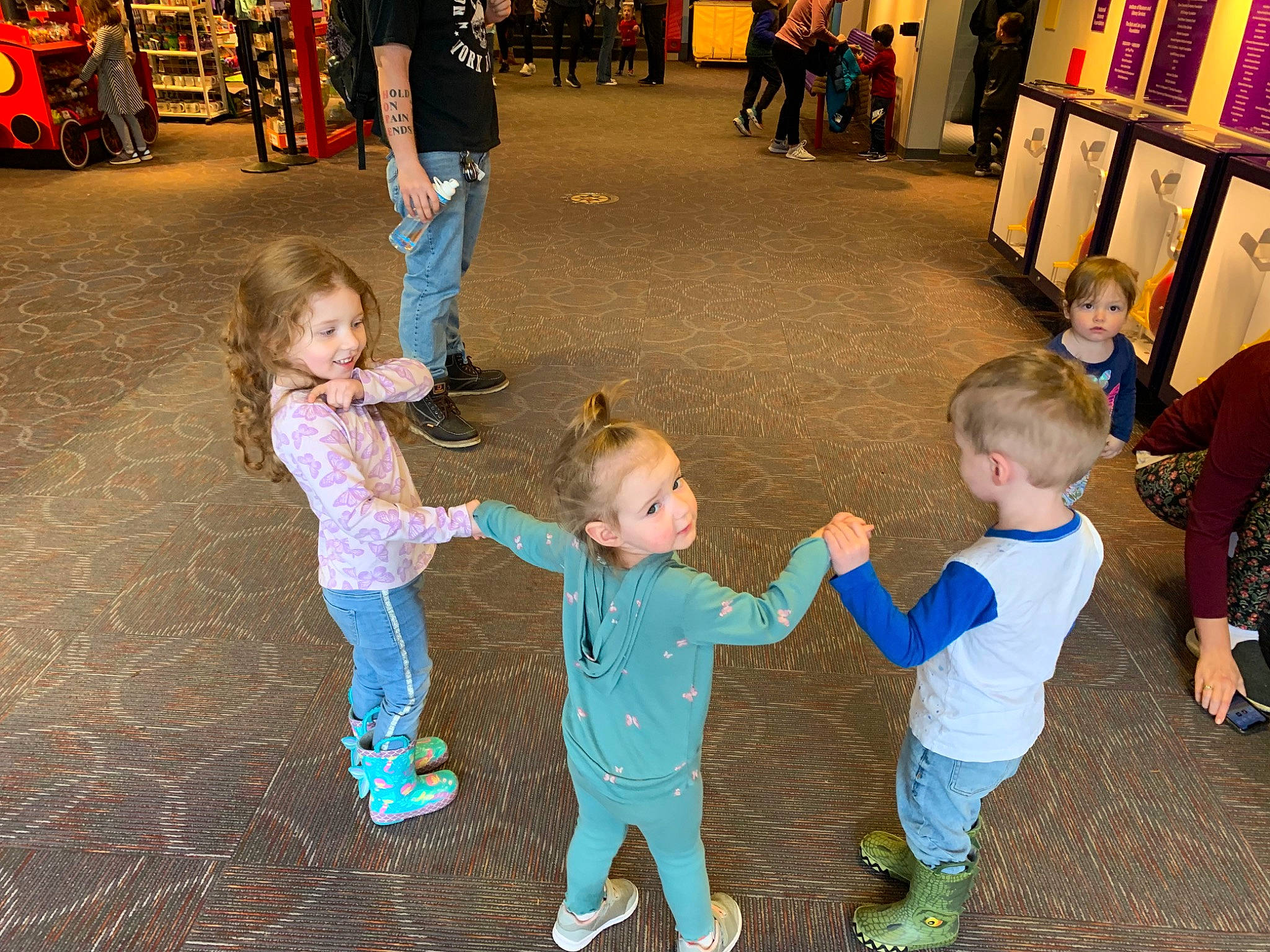 Hope is registered to the contest to win money with this photo: event, flooring, footwear, fun, gesture, hairstyle, happy, interaction, jeans, joy, leg, leisure, person, product, recreation, shoe, sneakers, standing, t_shirt, toddler