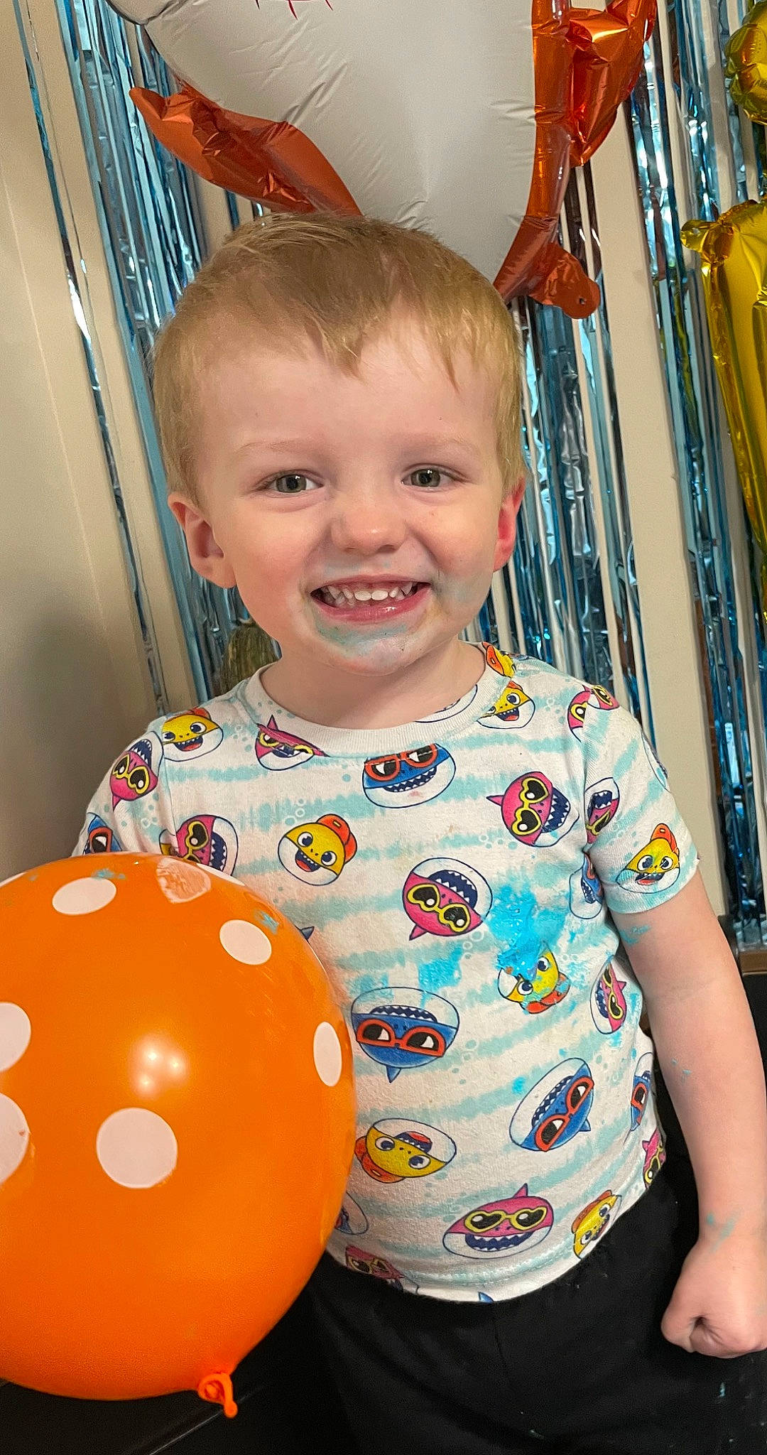 Elliot is registered to the contest to win money with this photo: baby, baby_toddler_clothing, balloon, beauty, cheek, child, event, eye, facial_expression, fun, happy, joy, orange, party_supply, people, person, product, sleeve, smile, standing