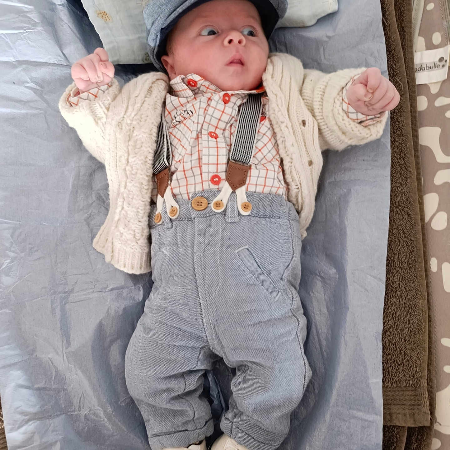 Moïse a rejoint le concours — aidez-le/la à gagner de superbes lots ! baby, blanket, button_up_shirt, cap, cardigan, changing_mat, cozy, cute, eyes_wide, hands_up, infant, knitwear, newborn, pillow, plaid_shirt, portrait, sneakers, surprised_expression, suspenders, trousers