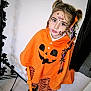 Kataleïa participe au concours pour gagner de l'argent avec cette photo : child, face_paint, halloween, orange_cape, pumpkin_face, costume, braided_hair, ribbons, indoor, curious_expression, young_girl, prop, striped_pants, decorations, floor, white_wall, black_decor, portrait, holiday, festive