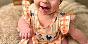 Renley is registered to the contest to win money with this photo: animal_print, baby, blanket, bow, checkered, child, cute, dress, fluffy, happy, headband, indoor, months, numbers, orange, portrait, sitting, smiling, white, wooden_blocks
