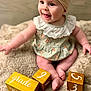 Renley is registered to the contest to win money with this photo: baby, infant, child, smiling, happy, head_wrap, floral_dress, wooden_blocks, numbers, letters, blanket, soft_texture, sitting, cute, portrait, indoors, closeup, skin, feet, hands