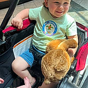 Ryett joined the competition — help win amazing prizes! toddler, child, plush_toy, stroller, birthday_crown, smiling, indoor, sunlight, floor_tiles, couch, shorts, tshirt, barefoot, baby_feet, happy, toy, person, celebration, candid, family