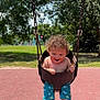 Junior joined the competition — help win amazing prizes! toddler, baby_swing, child, curly_hair, smiling, outdoor, playground, park, trees, sunny, grass, shorts, socks, happy, fun, summer, play, daylight, nature, person