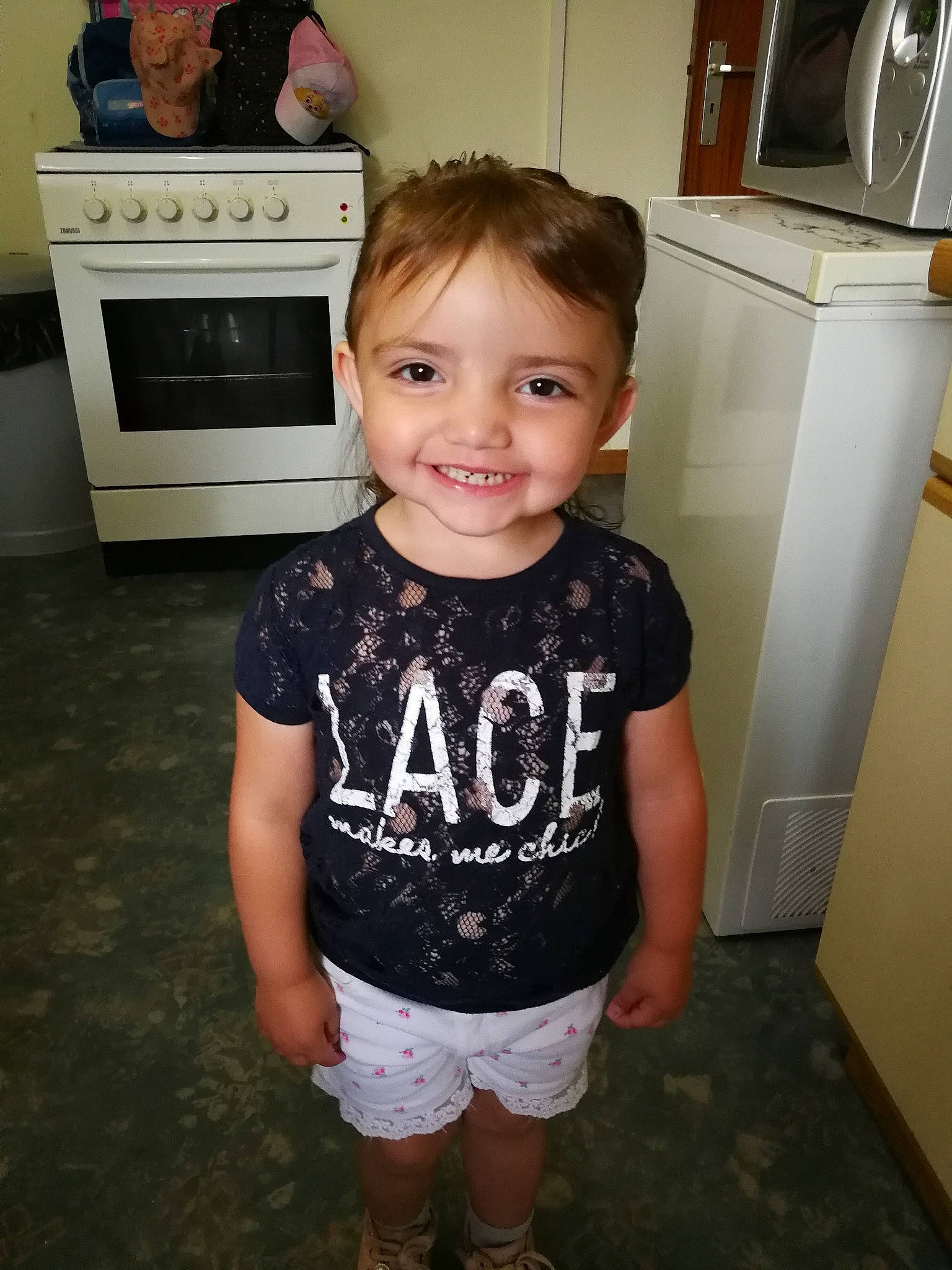 Inaya participe au concours pour gagner de l'argent avec cette photo : baby_toddler_clothing, child, flooring, fun, happy, home_appliance, joy, kitchen, kitchen_appliance, major_appliance, microwave_oven, pattern, person, refrigerator, shorts, sleeve, smile, standing, t_shirt, thigh