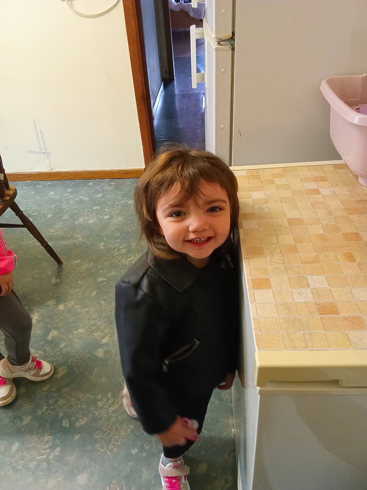 Inaya a rejoint le concours — aidez-le/la à gagner de superbes lots ! child, door, drawer, flip_flops, floor, flooring, footwear, fun, hardwood, joy, outdoor_shoe, person, room, sandal, sitting, smile, snapshot, standing, toddler, varnish