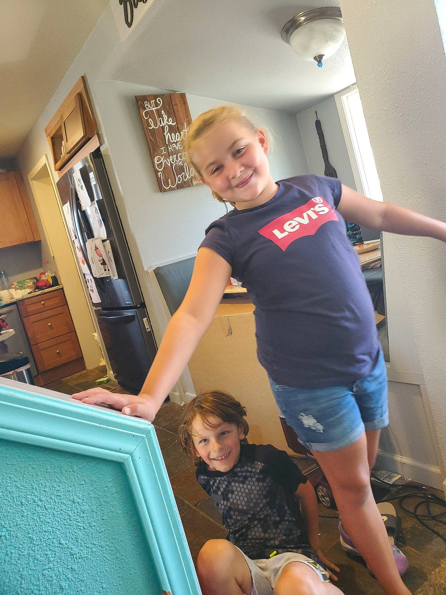 Chloe is registered to the contest to win money with this photo: elbow, electric_blue, flooring, fun, human_leg, joint, joy, knee, leg, leisure, muscle, person, picture_frame, shorts, shoulder, smile, standing, t_shirt, thigh, trunk