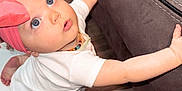 Everleigh is registered to the contest to win money with this photo: baby, blue_eyes, child, couch, crawling, curious, cute, floor, foot, furniture, hand, headband, indoor, infant, living_room, necklace, person, pink_bow, white_onesie, wooden_floor