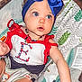 Everleigh joined the competition — help win amazing prizes! baby, child, blue_eyes, headband, bow, necklace, red_clothing, white_clothing, baby_seat, patterned_baby_seat, curious_expression, sitting, indoor, colorful, beads, infant, cute, portrait, person, young_child