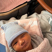 Anastasia joined the competition — help win amazing prizes! newborn, baby, blanket, hat, stroller, cozy, infant, sleepy, cute, soft, pastel, wrapped, child, portrait, face, clothing, babycare, resting, winking, indoors