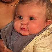 Alexander joined the competition — help win amazing prizes! baby, child, face, closeup, bib, clothing, skin, cheeks, eyes, mouth, expression, person, portrait, infant, cute, young, holding, adult, necklace, soft_lighting