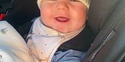 Reuben is registered to the contest to win money with this photo: accessory, baby, baby_bib, blanket, bundle, car_interior, car_seat, child, clothing, cute, happy, hat, indoors, infant, person, pom_poms, portrait, seatbelt, smile, warm