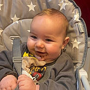 Reuben joined the competition — help win amazing prizes! baby, cheeks, child, chocolate, clothing, cute, face, food, hair, hands, happy, high_chair, indoor, infant, person, seat, sitting, smile, star_pattern, straps