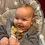baby, cheeks, child, chocolate, clothing, cute, face, food, hair, hands, happy, high_chair, indoor, infant, person, seat, sitting, smile, star_pattern, straps