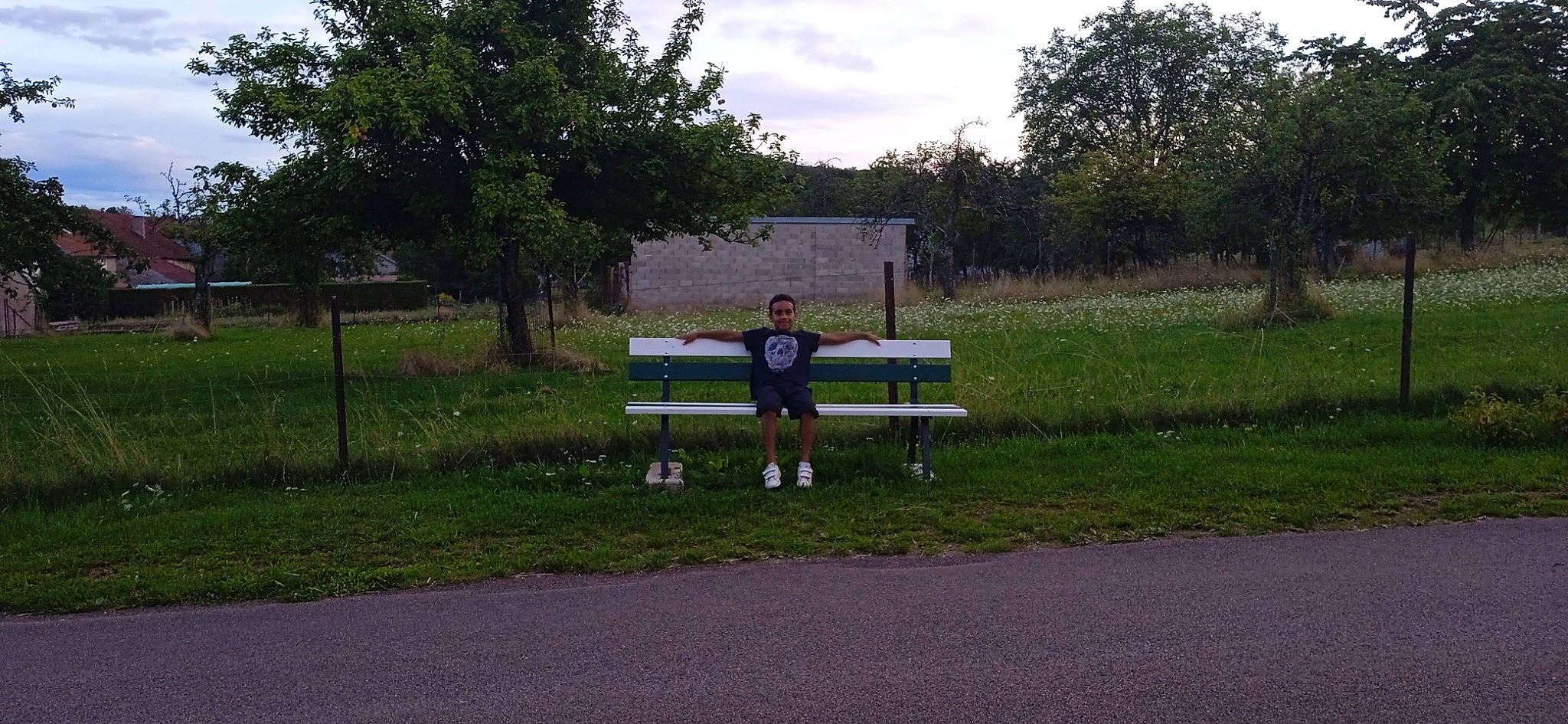 Arouna a rejoint le concours — aidez-le/la à gagner de superbes lots ! asphalt, bench, cloud, competition_event, furniture, grass, grassland, joy, landscape, lawn, leisure, outdoor_bench, outdoor_furniture, pasture, person, plant, recreation, road, sky, street_furniture