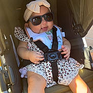 Ivy is registered to the contest to win money with this photo: baby, child, sunglasses, headband, stroller, seatbelt, smile, sunlight, footwear, clothing, baby_toy, summer, outdoor, cute, happy, infant, fashion, seat, accessory, babywear