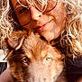 person, dog, puppy, curly_hair, glasses, close_up, face, brown_dog, blonde_hair, pet, affection, snuggle, portrait, warm_light, outdoor, cute, animal, companion, nose, happy