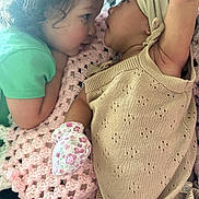Nova joined the competition — help win amazing prizes! baby, child, infant, blanket, crochet, knitwear, mittens, green_shirt, beige_outfit, face, closeup, indoor, cute, toddler, interaction, love, soft_texture, portrait, two_children, candid