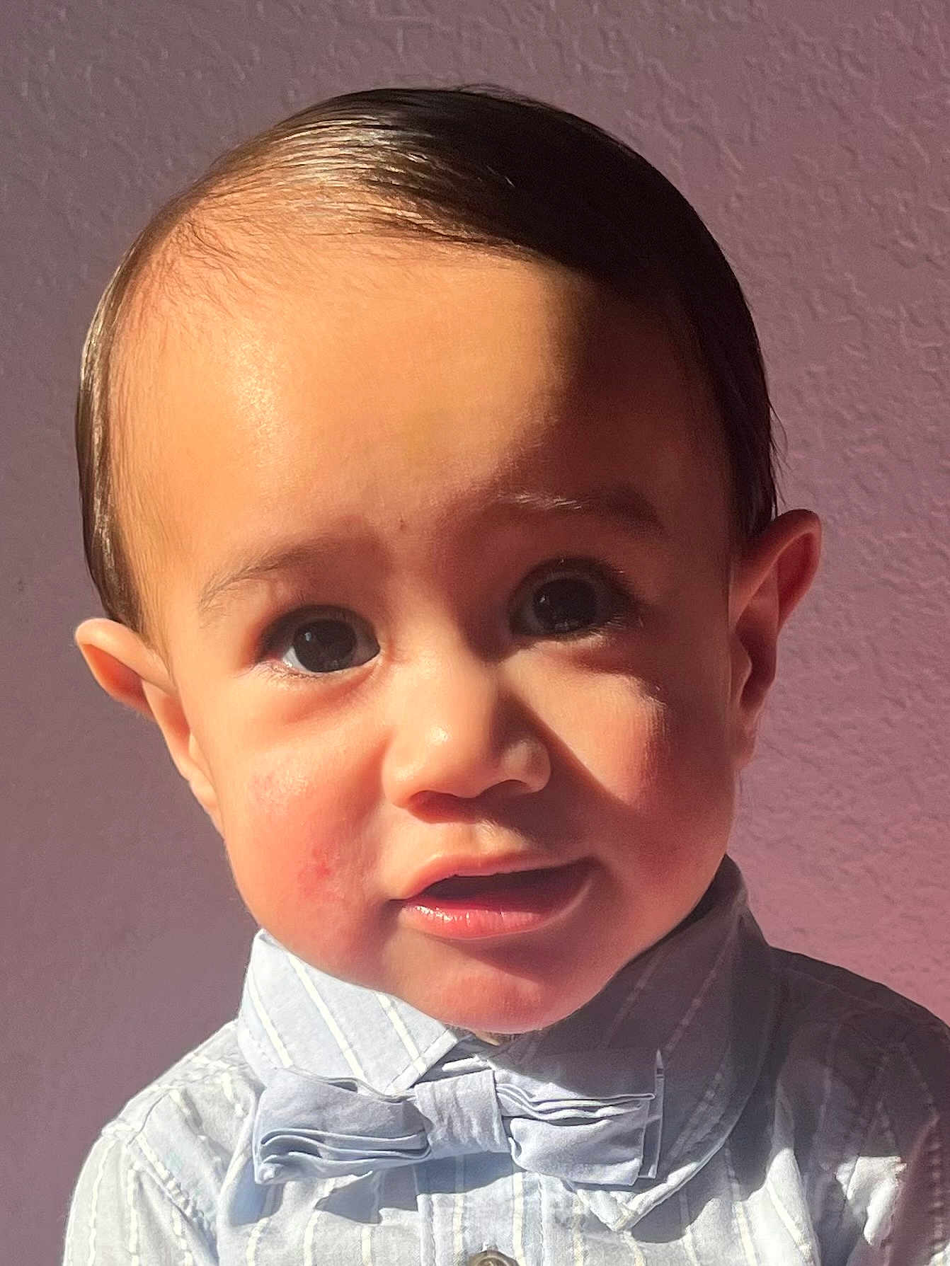 Thaddeus is registered to the contest to win money with this photo: toddler, child, face, portrait, expression, bow_tie, shirt, striped, indoors, sunlight, shadow, curious, young, person, head, skin, eyes, ears, fashion, cute