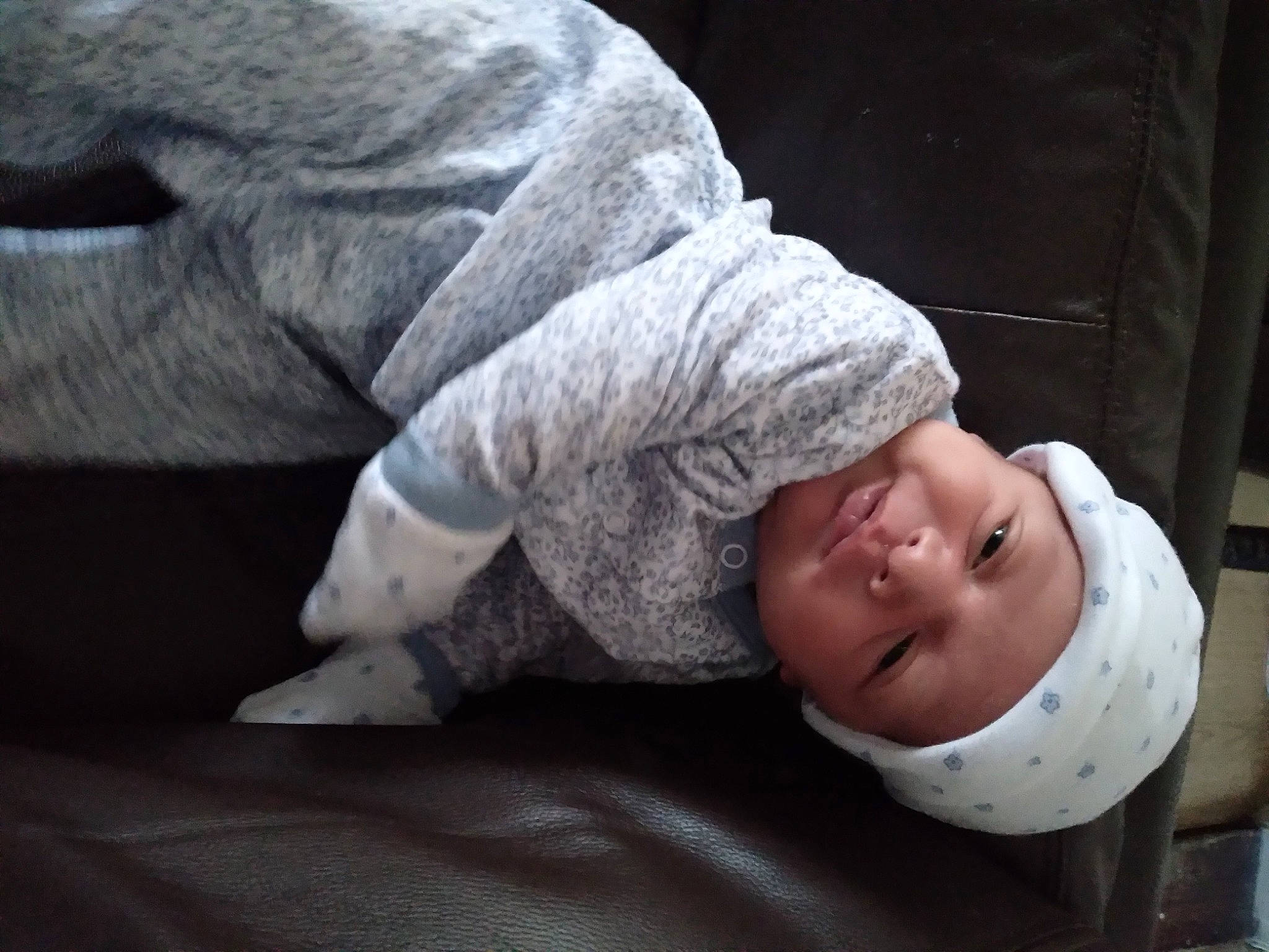 Charlie is registered to the contest to win money with this photo: baby, baby_toddler_clothing, cap, child, comfort, flash_photography, fur, gesture, grass, grey, hand, headwear, human_leg, linens, mammal, monochrome_photography, person, sitting, sleeve, smile