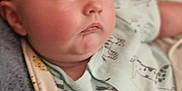 Mason is registered to the contest to win money with this photo: baby, infant, face, chubby_cheeks, onesie, animal_prints, blanket, soft, cute, portrait, newborn, sleepwear, skin, head, lying_down, child, indoors, young, expression, curious