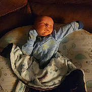 Mason joined the competition — help win amazing prizes! baby, sleeping, blanket, blue_onesie, couch, cushion, infant, peaceful, soft_lighting, animal_print, cozy, child, indoors, portrait, resting, cute, snuggled, warm, comfort, newborn