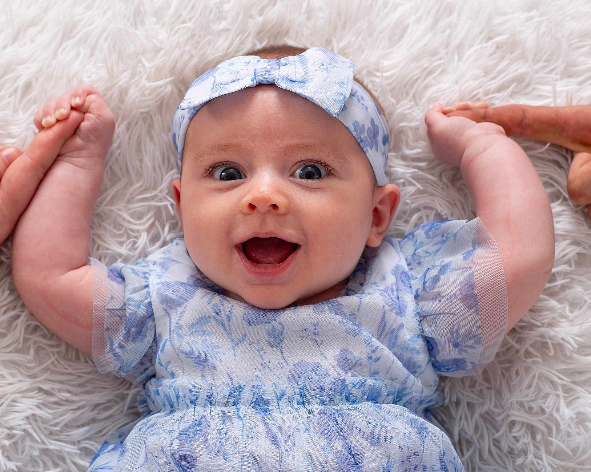 Willow joined the competition — help win amazing prizes! baby, infant, smile, happy, headband, blue_dress, floral_pattern, hands, feet, lying_down, white_rug, cute, child, portrait, closeup, person, skin, expression, indoors, playful