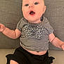Maya a rejoint le concours — aidez-le/la à gagner de superbes lots ! baby, child, infant, striped_shirt, bow, black_shorts, sitting, couch, gray_background, wide_eyes, open_mouth, cute, expression, indoors, young_child, person, clothing, skin, face, happy