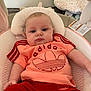 baby, infant, child, adidas, clothing, red_shorts, orange_shirt, baby_seat, cushion, pillow, indoor, portrait, face, head, eyes, person, soft_toys, comfort, casual_wear, home
