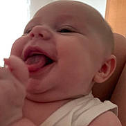 Maya participe au concours pour gagner de l'argent avec cette photo : baby, infant, smiling, tongue_out, close_up, white_clothing, arm, face, happy, indoor, window, curtains, skin, person, child, head, mouth, ear, cheek, room