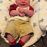 Kamron is registered to the contest to win money with this photo: baby, smiling, infant, child, clothing, socks, shorts, shirt, blanket, zebra_pattern, bottle, feeding, chair, cozy, happy, portrait, indoors, cute, hands, face