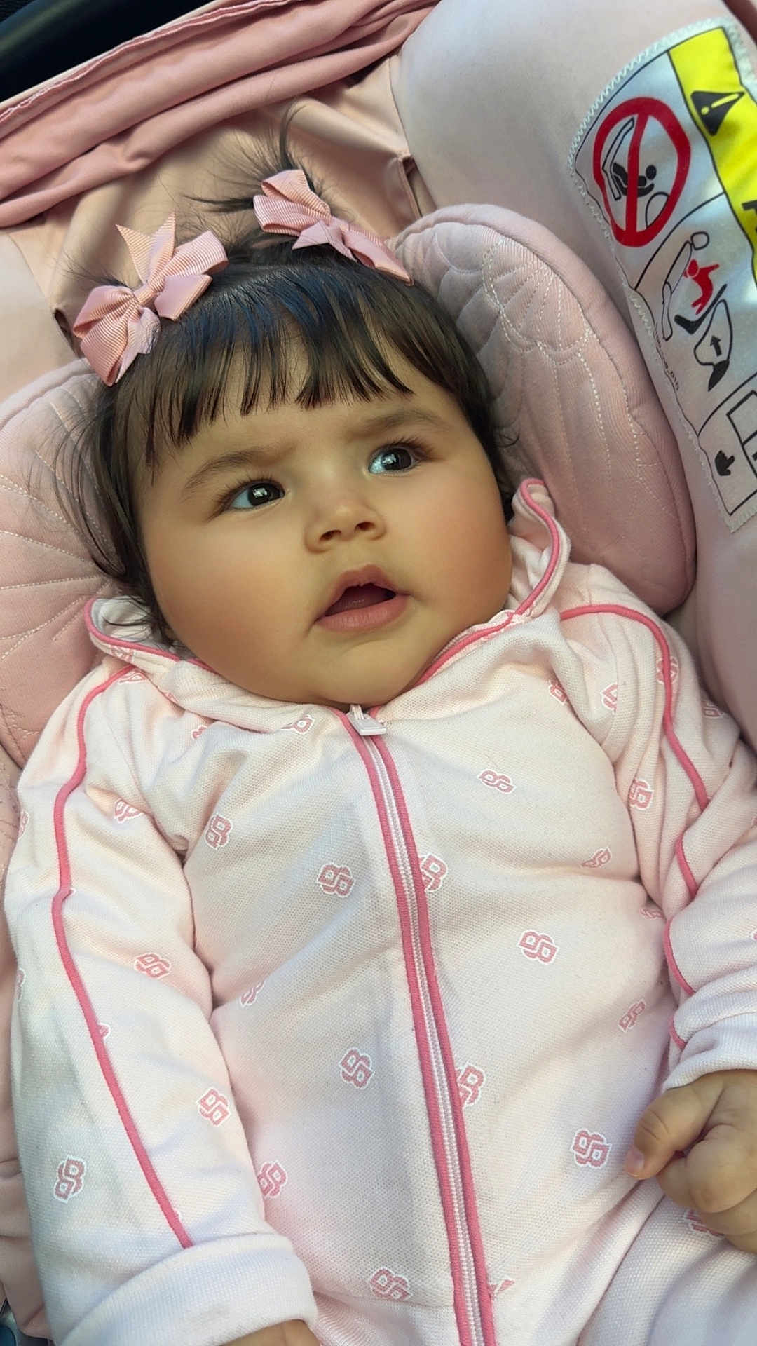 Sinaï participe au concours pour gagner de l'argent avec cette photo : baby, child, pink_bows, pink_outfit, cushion, seat, face, curious, indoors, childcare, infant, cozy, clothing, person, head, hand, expression, cute, soft, portrait