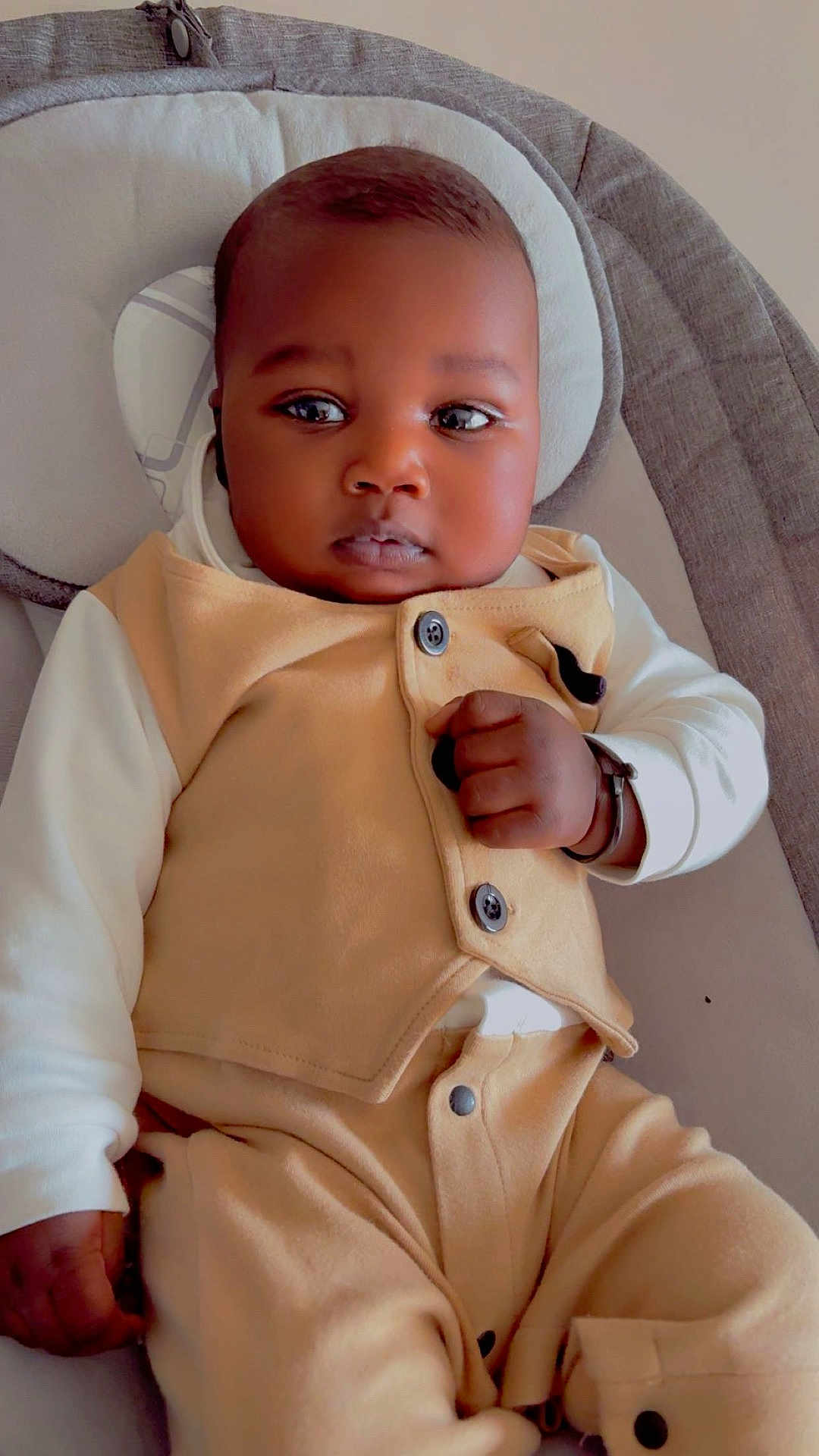 Mouhamed a rejoint le concours — aidez-le/la à gagner de superbes lots ! baby, infant, child, face, clothing, onesie, vest, hand, fist, seated, indoor, cushion, headrest, skin, portrait, cute, young, sleepy, expression, adorable