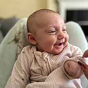 Amelie joined the competition — help win amazing prizes! baby, smiling, laughing, infant, pajamas, hand, cozy, blurred_background, closeup, cute, child, person, indoor, soft_light, happy, skin, face, newborn, portrait, comfort