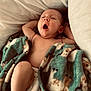 baby, infant, yawning, blanket, animal_print, diaper, sleeping, pillow, bed, comfort, cozy, soft_fabric, child, cute, relaxed, skin, portrait, indoors, resting, peaceful