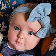 Lou a rejoint le concours — aidez-le/la à gagner de superbes lots ! baby, blue_eyes, bow, carrier, child, close_up, clothing, cute, expression, face, head, headband, indoors, infant, patterned_fabric, portrait, seat_belt, skin, soft_lighting, young_child