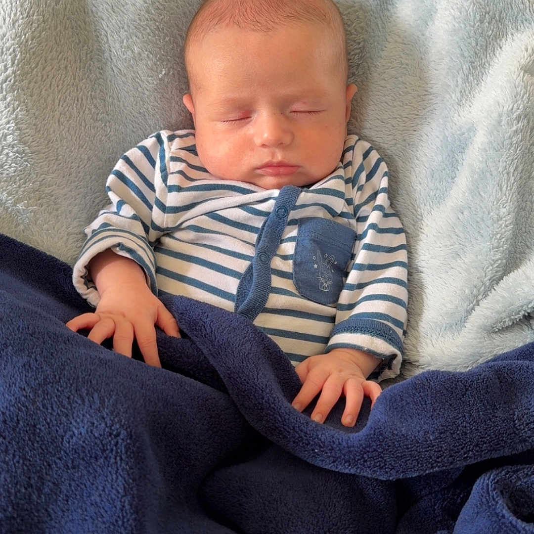 Enéo participe au concours pour gagner de l'argent avec cette photo : baby, blanket, child, comfort, cozy, cute, face, hands, head, indoor, infant, newborn, one_person, pale_skin, peaceful, portrait, resting, sleeping, soft_texture, striped_clothing