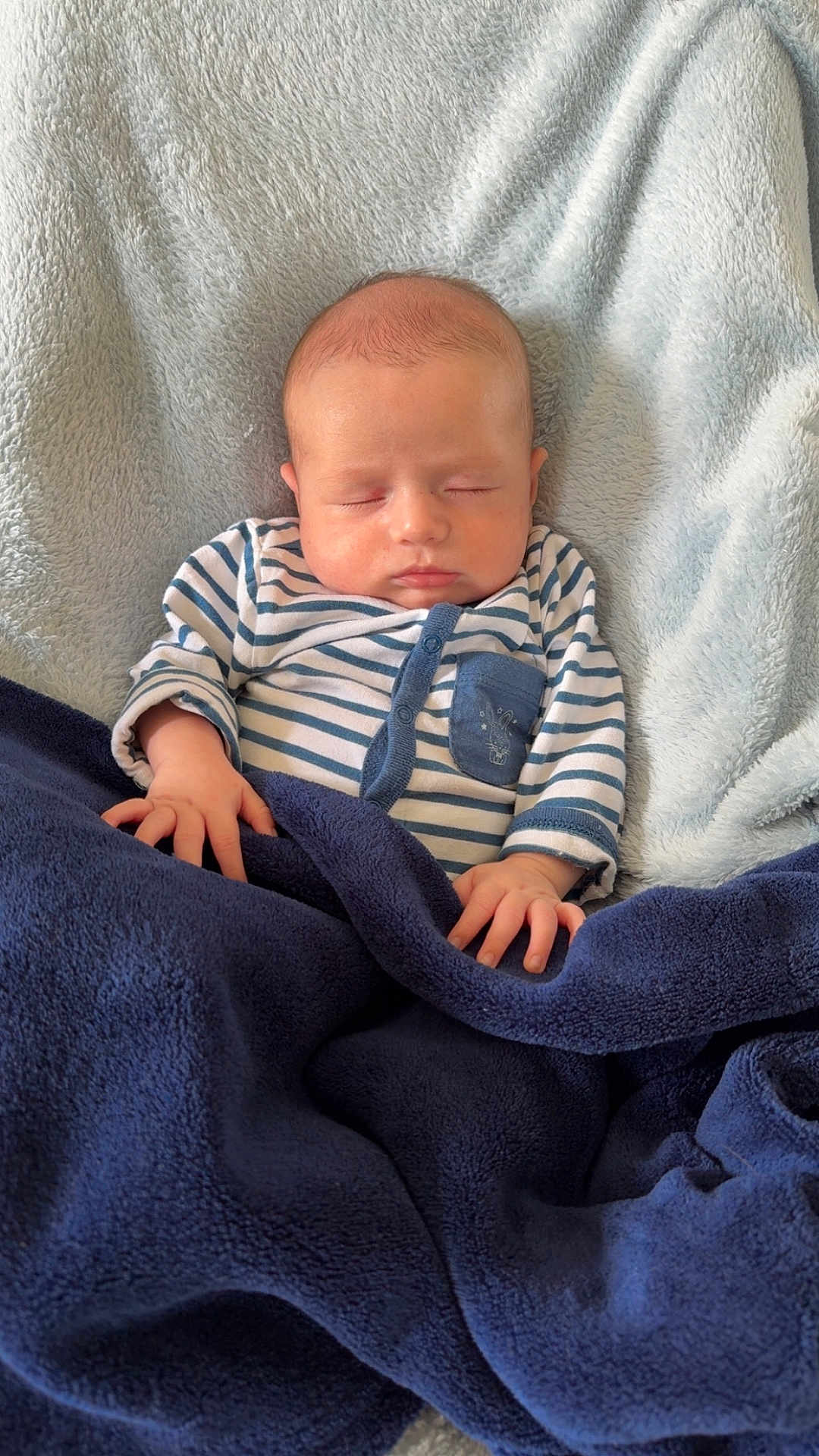 Enéo participe au concours pour gagner de l'argent avec cette photo : baby, sleeping, blanket, striped_clothing, infant, cozy, portrait, soft_texture, hands, peaceful, cute, child, one_person, indoor, pale_skin, head, face, resting, newborn, comfort