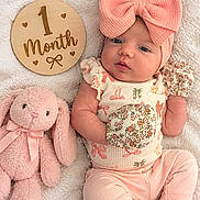 Kennedy joined the competition — help win amazing prizes! baby, infant, child, portrait, lying_down, pink, bow, headband, floral_outfit, onesie, plush_toy, bunny, stuffed_animal, milestone_sign, one_month, blanket, cozy, indoor, cute, photography