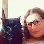 animal, black_cat, cat, closeup, companion, cozy, curly_hair, cute, feline, friendly, furry, glasses, home, indoor, person, pet, portrait, relaxed, smile, soft_light