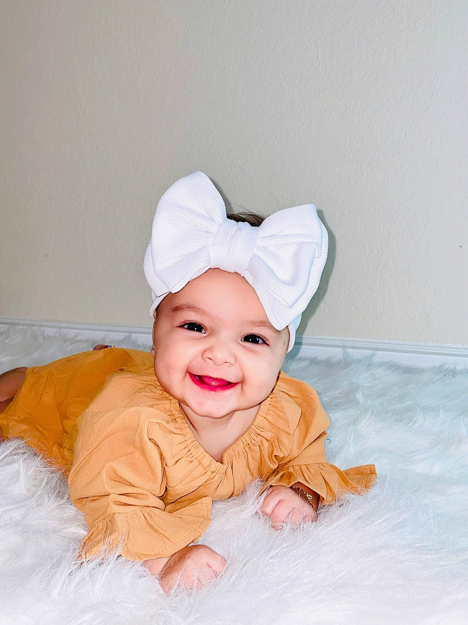 Isabella is registered to the contest to win money with this photo: baby, baby_laughing, baby_toddler_clothing, cap, child, comfort, face, fashion_accessory, flash_photography, flooring, fun, fur, happy, hat, head, headwear, human_body, joy, person, sitting