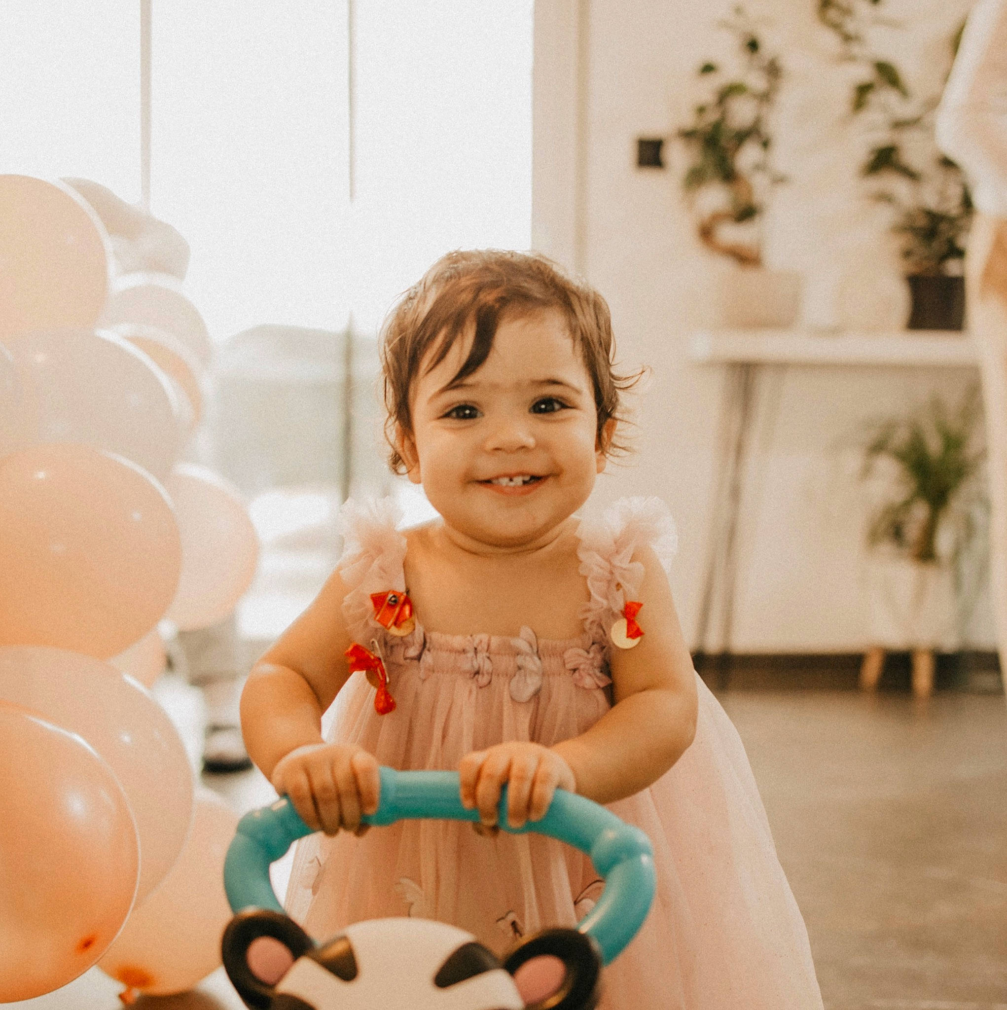 Daphné participe au concours pour gagner de l'argent avec cette photo : baby, baby_toddler_clothing, balloon, child, dress, event, flash_photography, flowerpot, fun, happy, houseplant, joy, leisure, party_supply, person, plant, sitting, skin, smile, sweetness