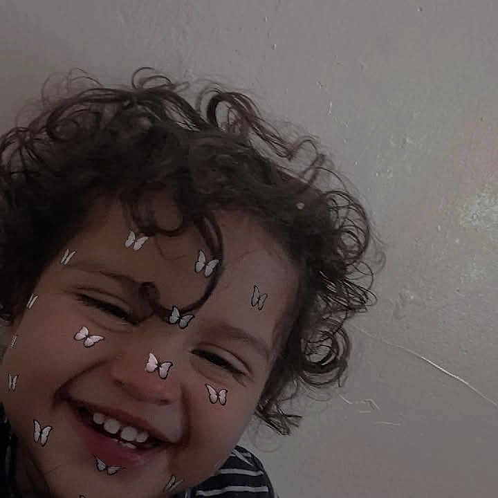 Mateo Begue is registered to the contest to win money with this photo: butterfly_stickers, child, childhood, closeup, curly_hair, cute, expression, face, happy, head, indoor, joy, person, playful, portrait, skin, smiling, striped_shirt, toddler, wall