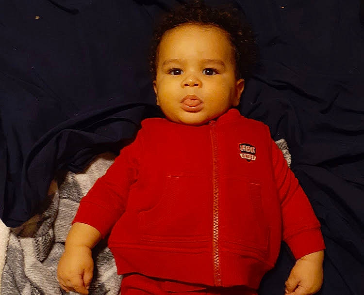 Logan joined the competition — help win amazing prizes! arm, baby, cheek, child, face, human, nose, person, red, sitting, sleeve, smile, standing, toddler