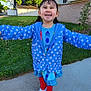 child, daylight, dress, girl, grass, happy, house, jacket, nature, outdoor, person, pigtails, polka_dot, portrait, red_leggings, sidewalk, smiling, suburban, trees, white_shoes