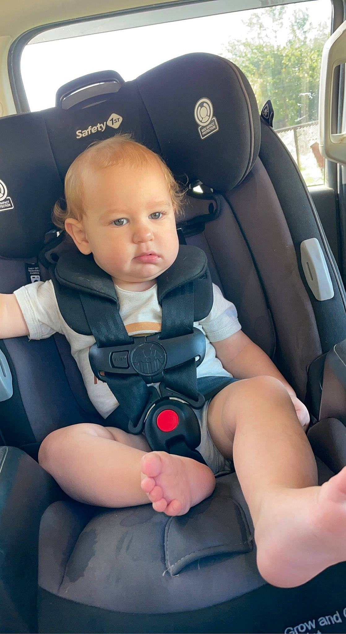 Jaxon is registered to the contest to win money with this photo: arm, auto_part, automotive_design, baby, baby_products, baby_toddler_clothing, blue, car, car_seat, car_seat_cover, comfort, head_restraint, leg, motor_vehicle, person, plant, product, seat_belt, sitting, thigh