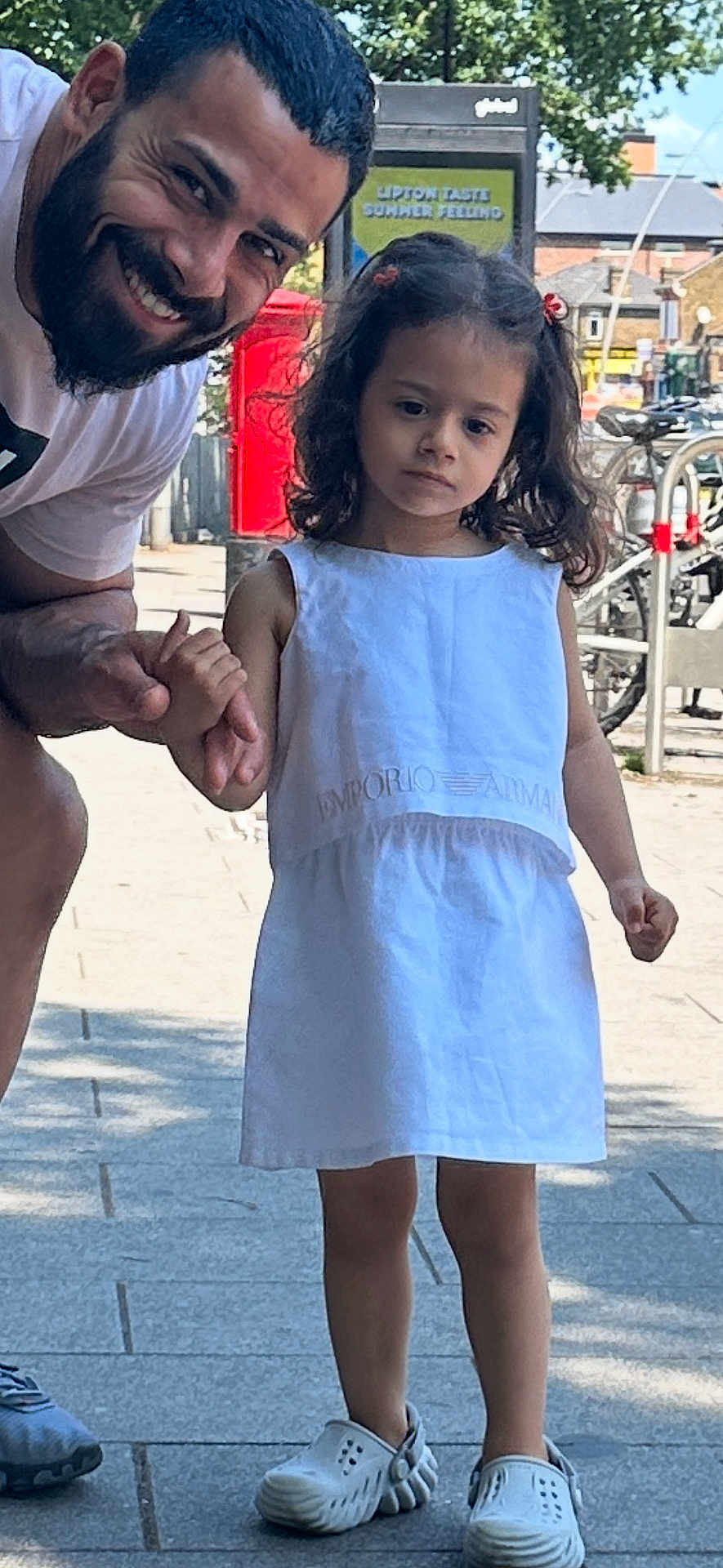 Marta joined the competition — help win amazing prizes! man, child, girl, white_dress, holding_hands, sidewalk, outdoor, smiling, beard, shoes, bicycle, red_mailbox, tree, urban, daylight, casual_clothing, person, curly_hair, public_space, street