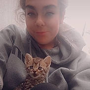 Oliver joined the competition — help win amazing prizes! person, kitten, cat, hoodie, indoor, portrait, cute, cozy, casual, young_adult, smile, hair_up, sitting, pet, animal, face, looking_at_camera, comfort, relaxed, feline